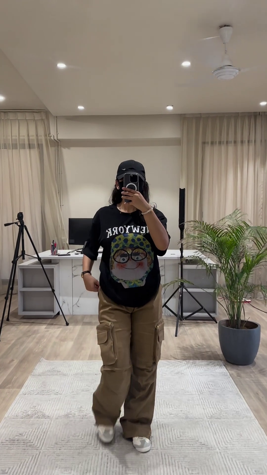Urban Chic Outfit: White Graphic Tee, Rust Cargo Pants, and Black Cap