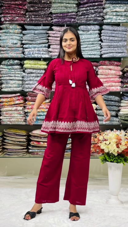 Women’s Red Embroidered Kurti Pant Set – White Threadwork Details with Boutique Shelf Backdrop