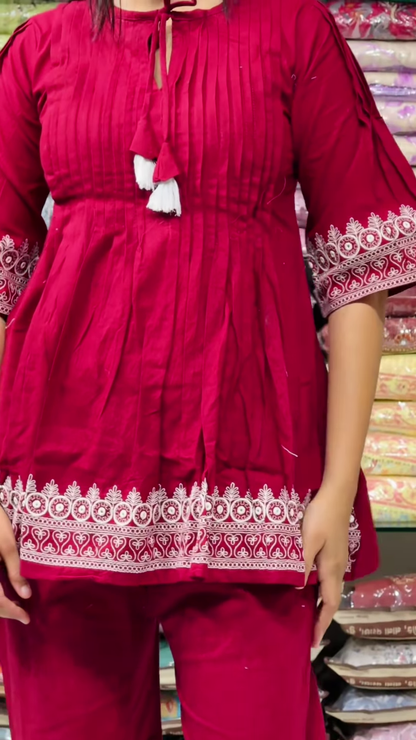 Women’s Red Embroidered Kurti Pant Set – White Threadwork Details with Boutique Shelf Backdrop