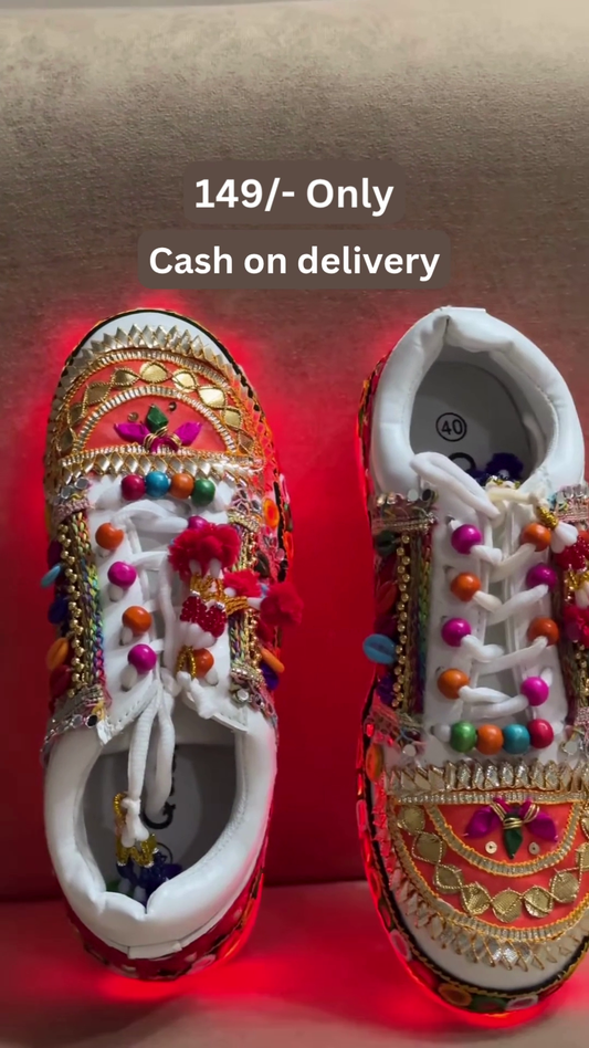Unisex White Ethnic Mojari Footwear with Multicolor Bead Embroidery – Festive Pair with Red Light Showcase Styling