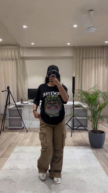 Urban Chic Outfit: White Graphic Tee, Rust Cargo Pants, and Black Cap