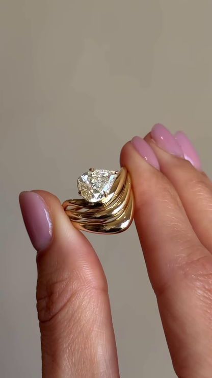 Sculptural Gold-Toned Ring with Wavy Design and Pear-Shaped Clear Gemstone