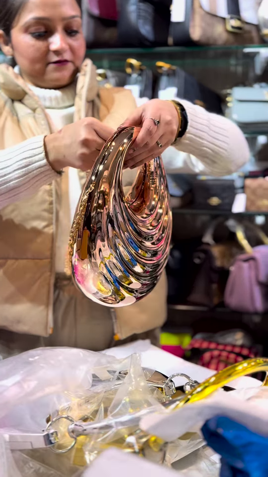 Sculptural Rose Gold-Toned Metallic Clutch with Wavy Design and Chain Strap